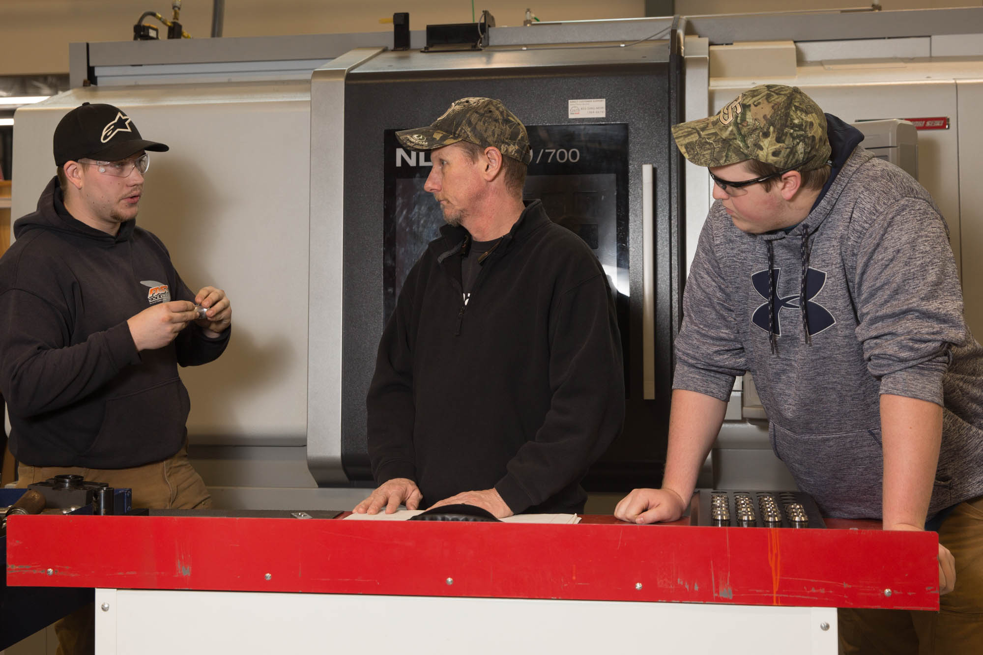 Three men doing CNC machining