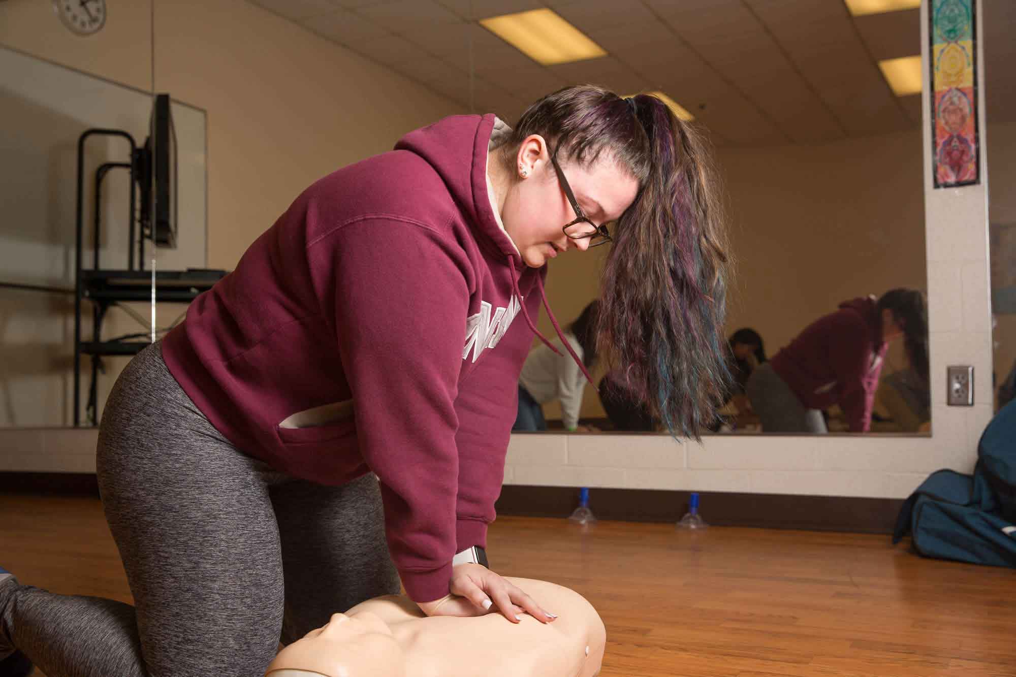 A student performs CPR on a practice dummy