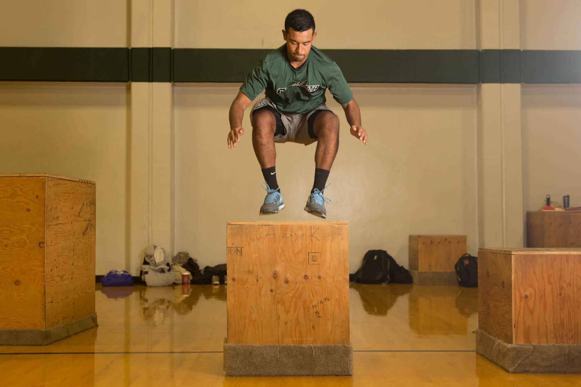 Student jumping onto a large wooden box