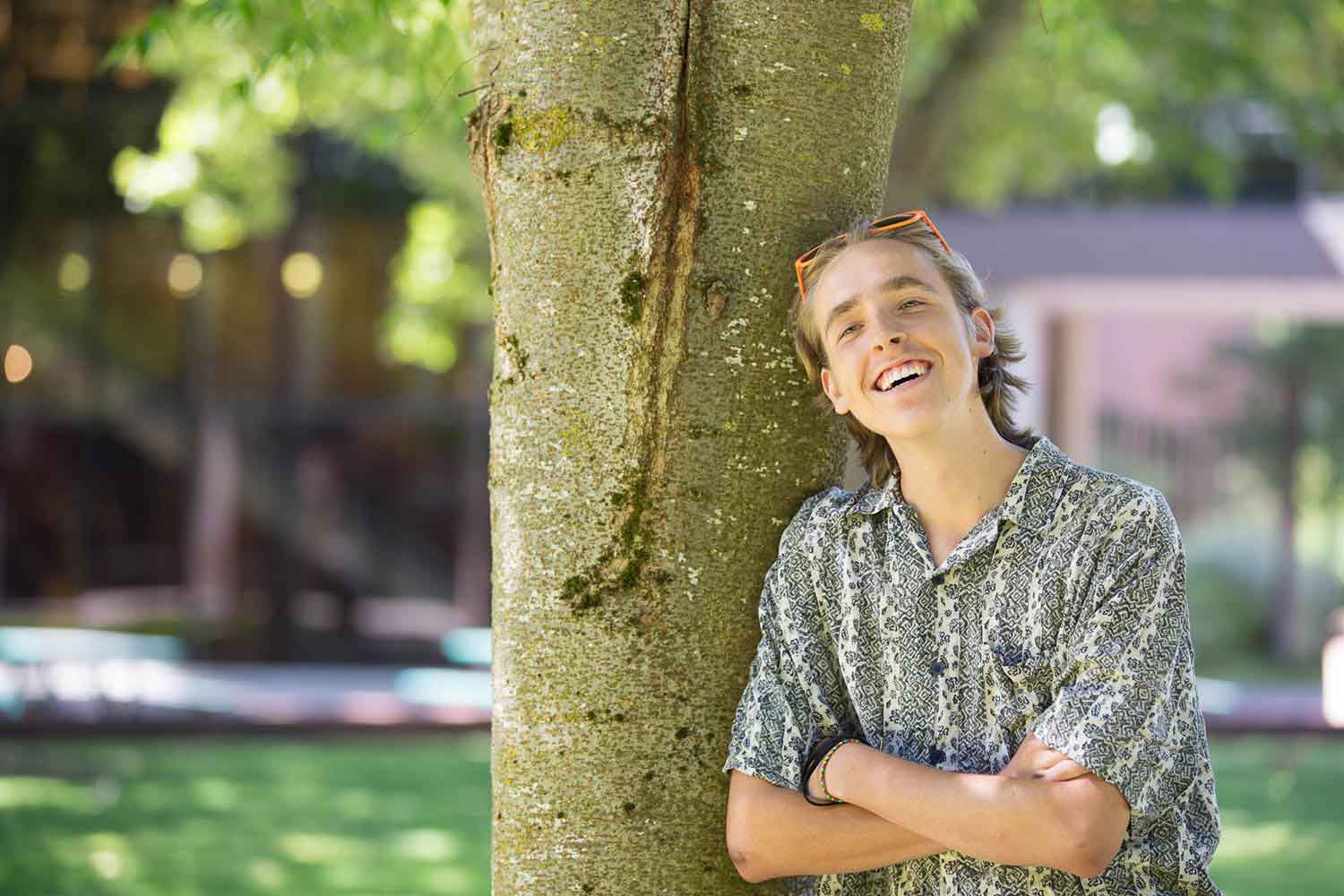 Student leaning against tree