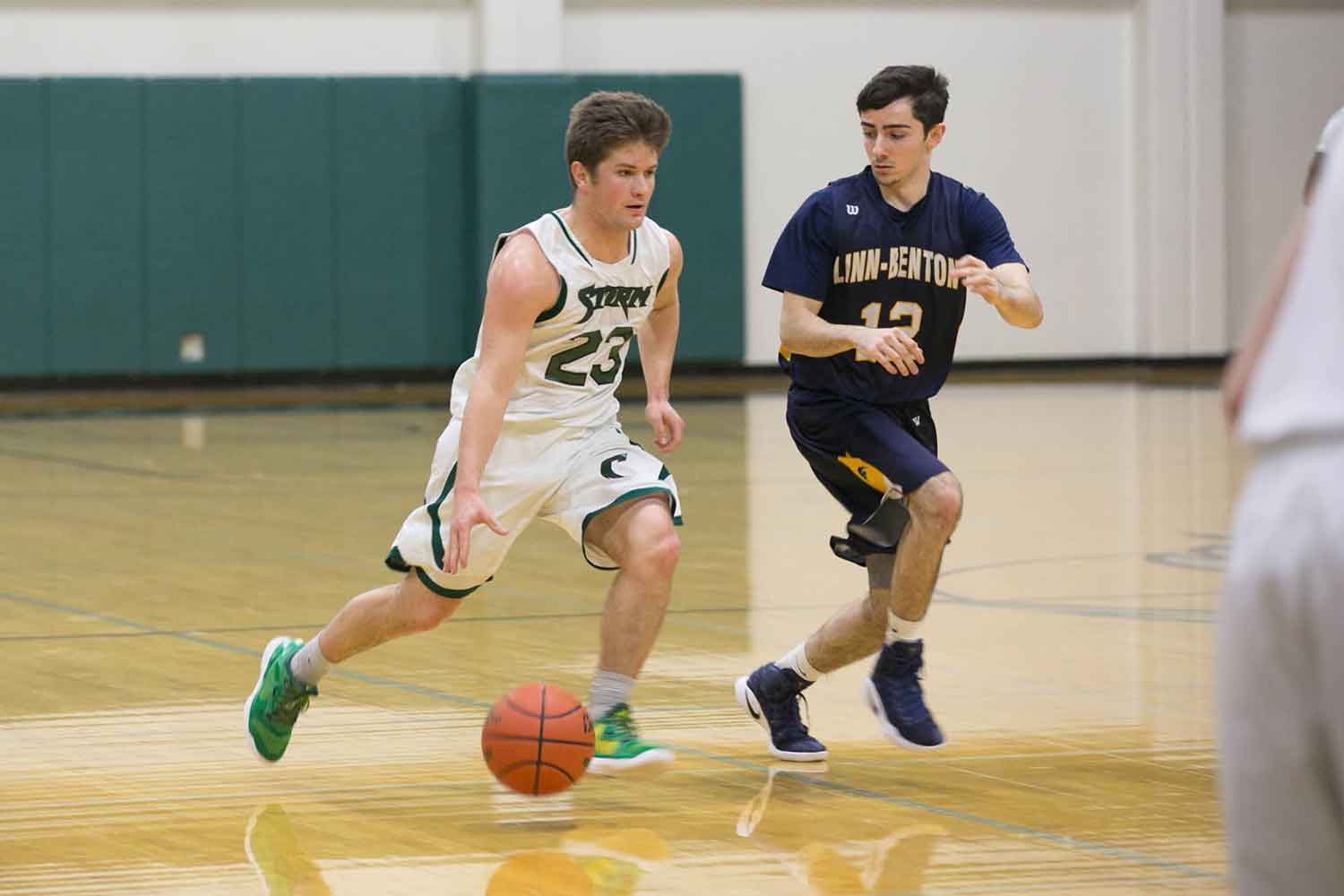 A men's basketball player moves down the court with the ball