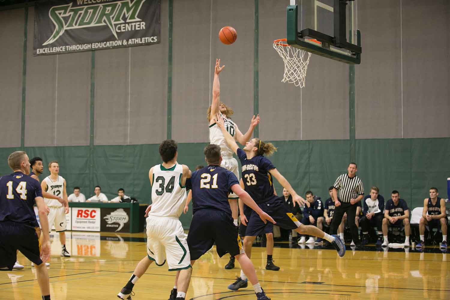 A men's basketball player jumps high for a basket