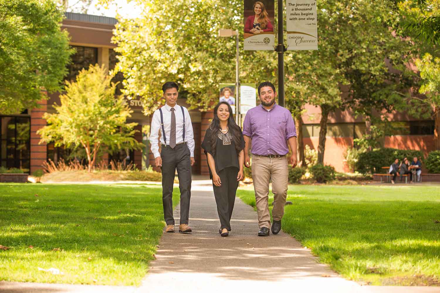 Three students walking outside through the quad 