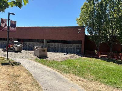 The exterior of Building 7 with gravel covering a walkway and construction equipment.