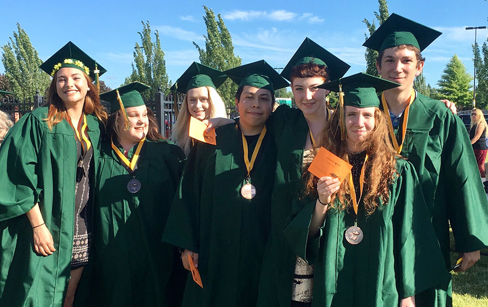 A group of graduates in regalia from High School Partnerships