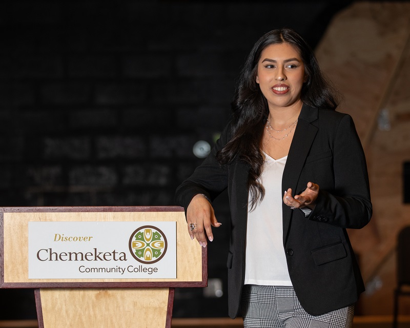 A student standing next to a podium giving a speech